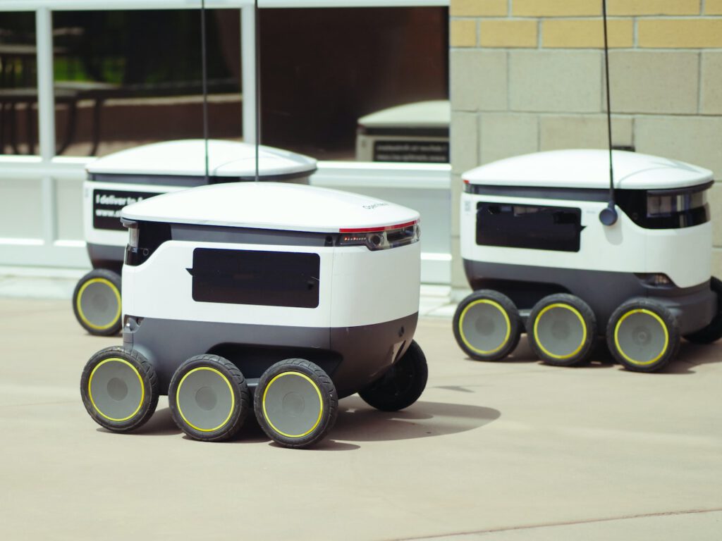 Three delivery robots are on their way to deliver peoples orders